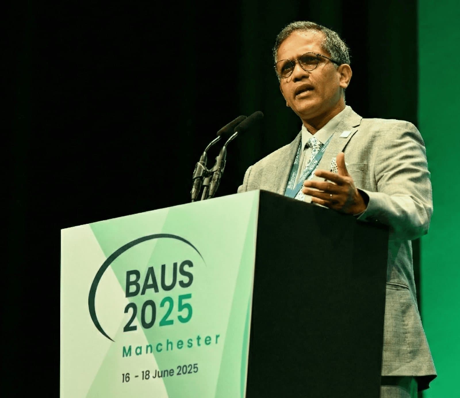 Joe Philip speaking at the BAUS 2025 lectern in Manchester