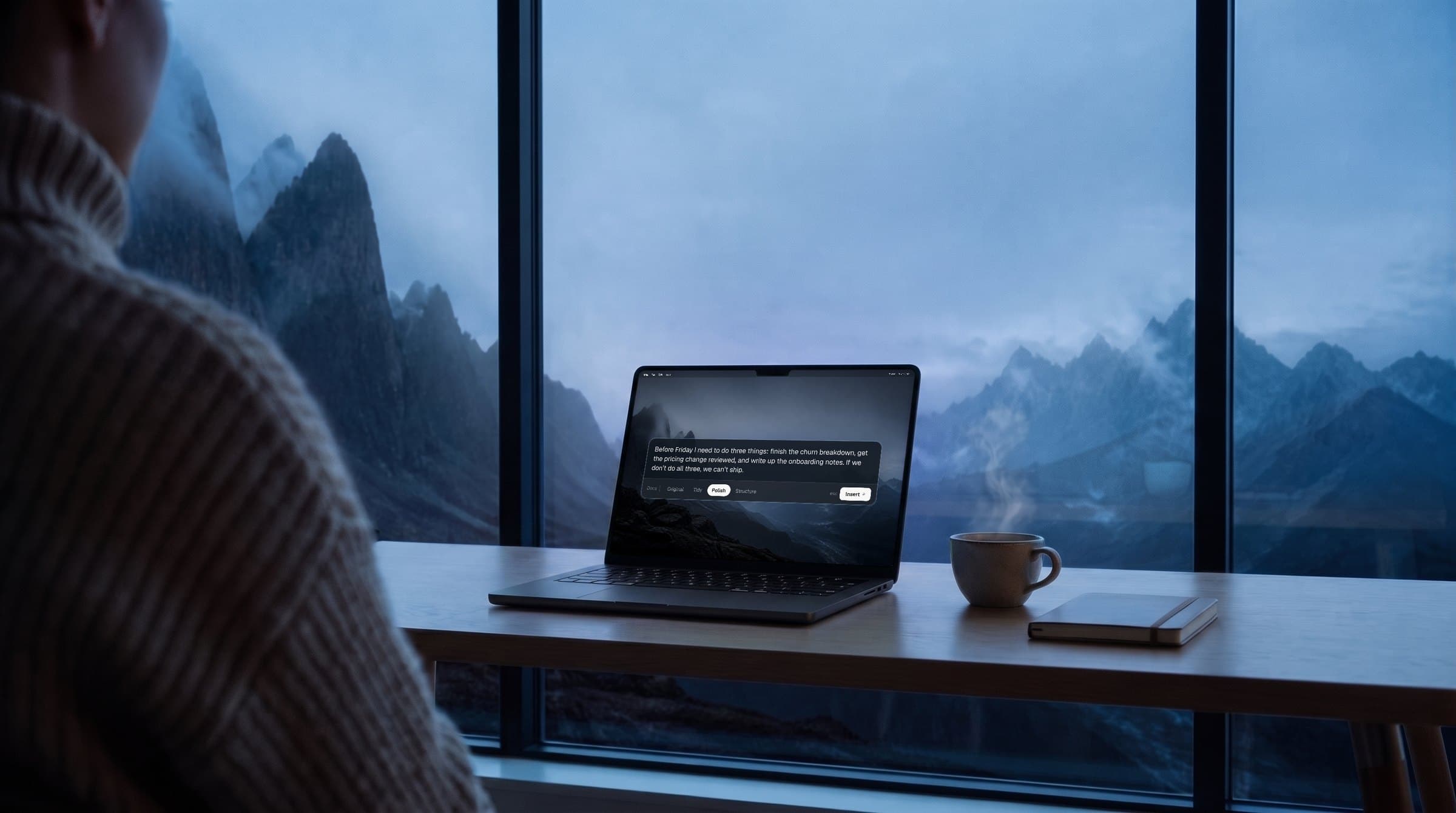 Someone at a desk by a window onto misty peaks, Speaklively’s panel on a Space Black MacBook Pro