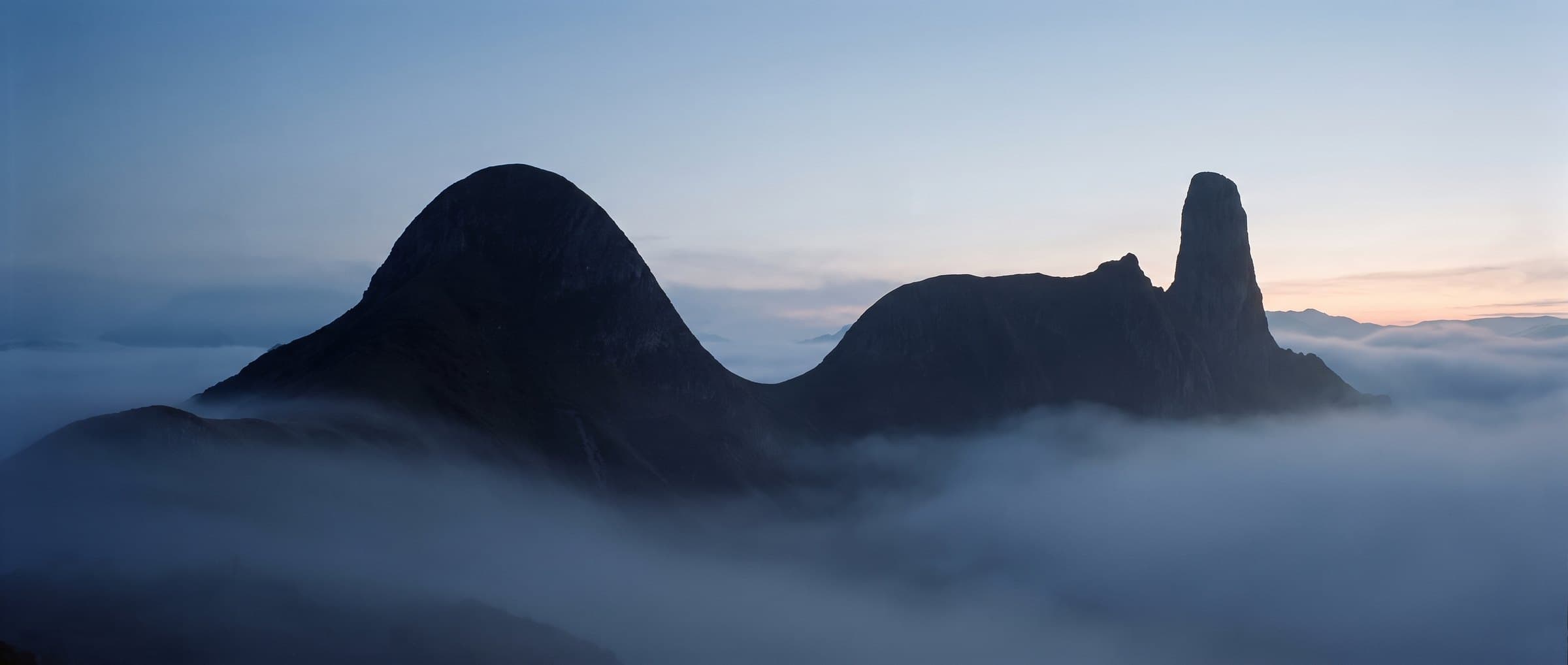 A mountain ridge at dawn whose outline traces the Speaklively mark: a wave, a level line, a tall pinnacle